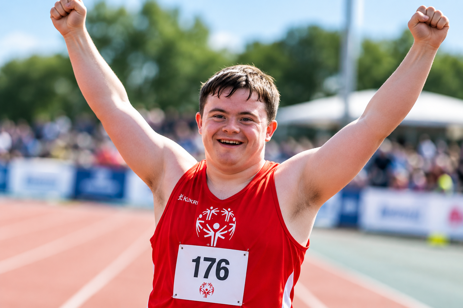 Athlete celebrating on an athletics track with arms raised
